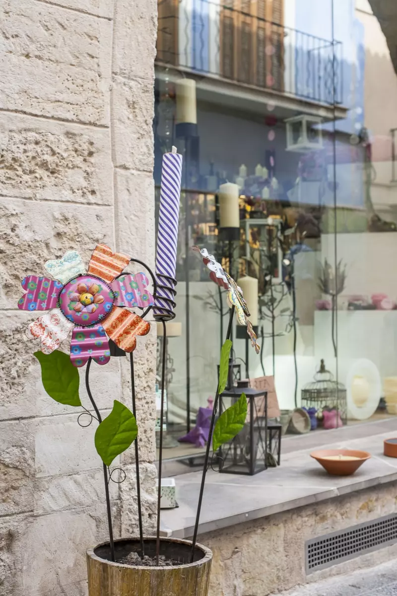 Mallorquinische Geschäftsstraße mit dekorativem Straßenmotiv und lokalen Produkten im Schaufenster Mallorquinische Geschäftsstraße mit dekorativem Straßenmotiv und lokalen Produkten im Schaufenster